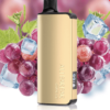 The Bundle 3 Pcs - Alibarbar Ingot 9000 gold vape device, featuring “GRAPE ICE” in elegant print, is artfully showcased amid grapes, ice cubes, and green leaves.